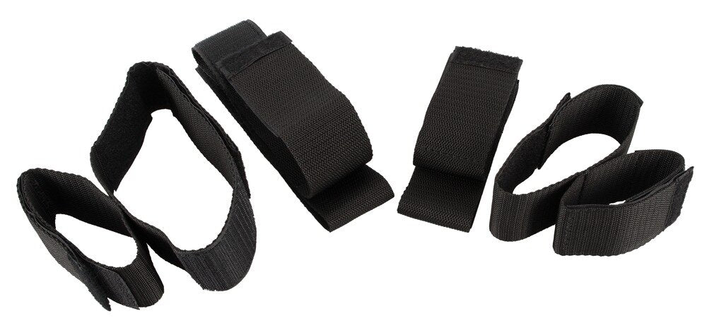 Schwarze Bad Kitty Arm- und Fußfesseln aus Leder für BDSM, mit Schnallenverschluss und gepolsterten Riemen.